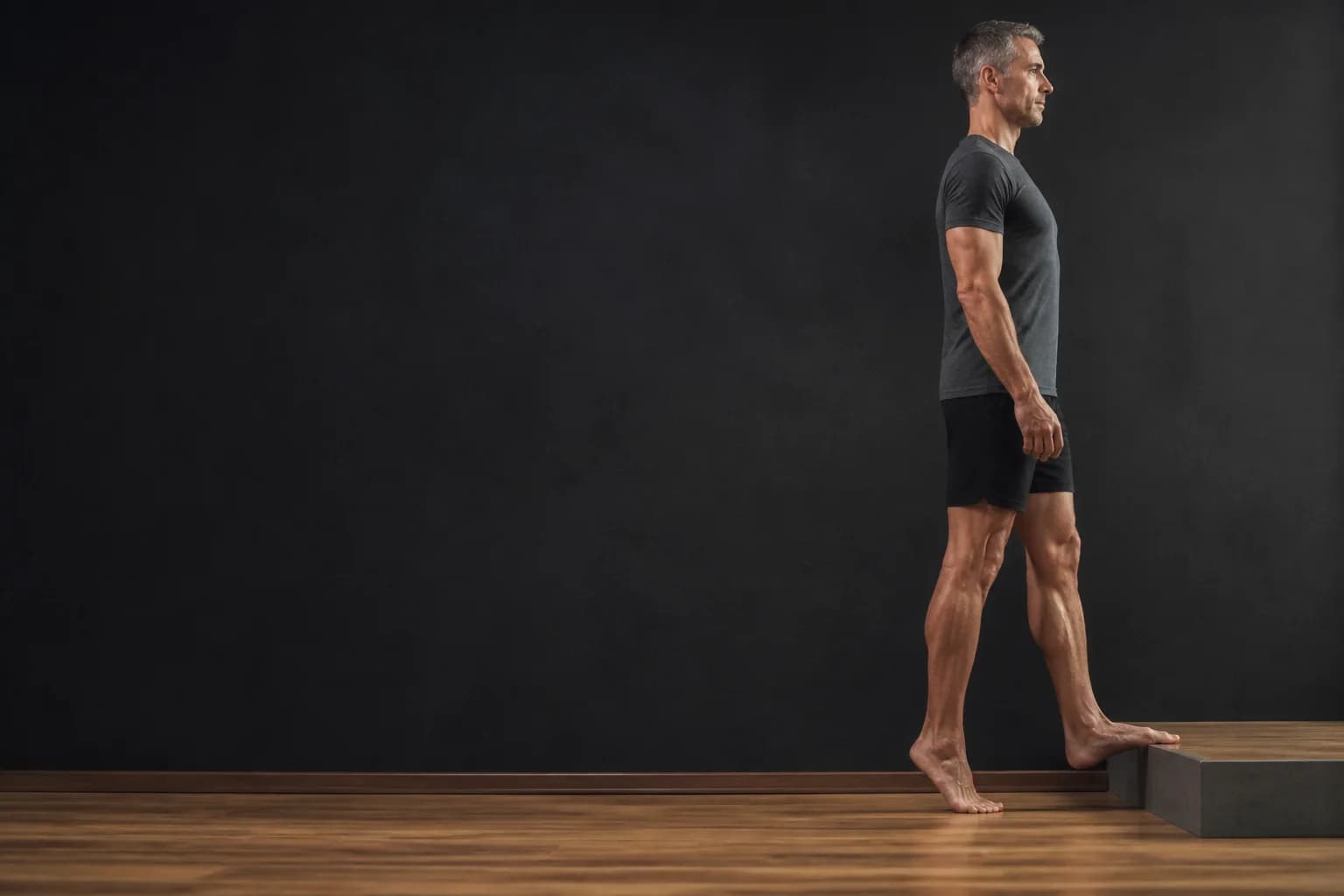 Man performing a controlled single-leg calf raise during tendon rehabilitation